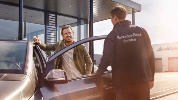 Zwei M�nner die sich unterhalten, einer hat eine Mercedes-Benz Service Jacke an und der andere ist ein Kunde